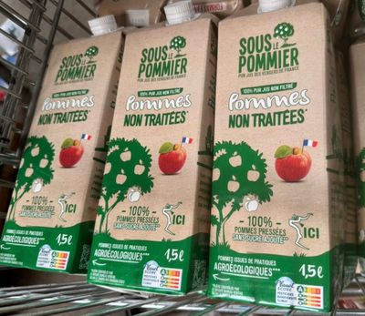 quatre cartons de jus de fruits sont posés sur une étagère dans une épicerie