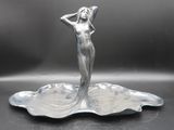 a silver statue of a woman standing on a plate