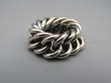 gros plan d'une bague en argent sur une surface blanche