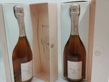 deux bouteilles de champagne dans un coffret rose, avec une carte posée dessus