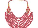 un gros plan d'un collier composé de perles rouges sur fond blanc