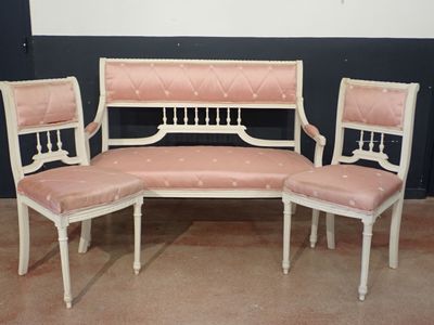 three chairs and a bench in a room with black walls