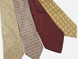three different colored neck ties are lined up on a white surface