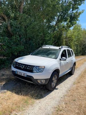 une voiture blanche garée sur un chemin de terre