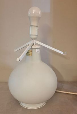 un vase blanc muni d'une anse, posé sur une table