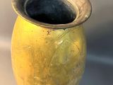 a yellow vase that is sitting on a white surface