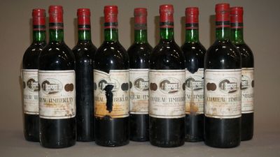 six bouteilles de vin sont alignées sur une table