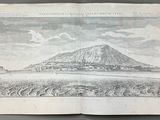 an old book with a drawing of a mountain in the background