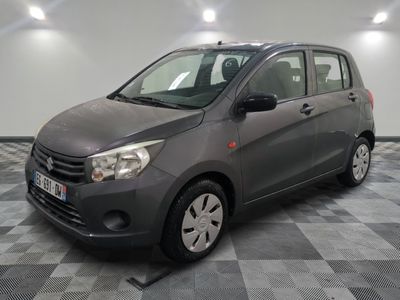La petite voiture grise est garée dans le garage, sur un sol à damier.