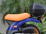 a blue and orange motorcycle parked in front of a building
