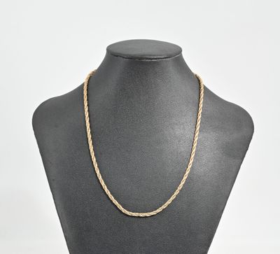 un collier en or en forme de corde autour du cou d'un mannequin