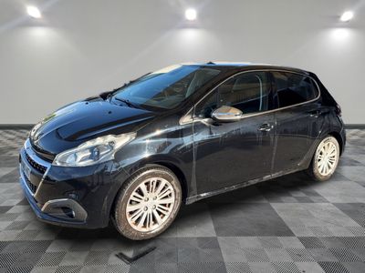 une voiture noire est garée dans une pièce au sol en damier