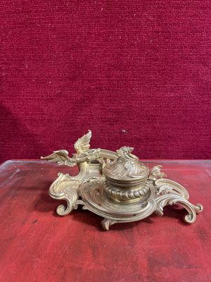 un bougeoir ancien en laiton surmonté d'un oiseau