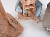 several clay sculptures of a man sitting in a chair and a woman sitting in a chair