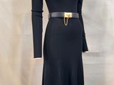 a black dress with a gold belt on a mannequin