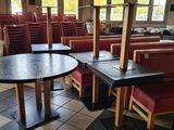 tables and chairs in a restaurant with a television in the background