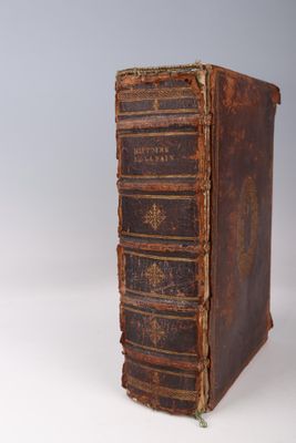 an old book sitting on top of a table next to a white wall