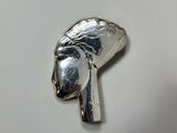 a silver object on a white surface that looks like a woman ' s head