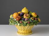 un saladier jaune rempli de fruits et de légumes posé sur une table