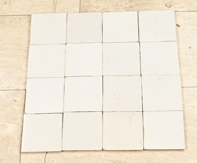 un carré de carrelage blanc sur le sol d'une salle de bains