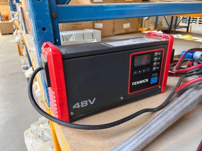 un chargeur de batterie rouge et noir posé sur une table