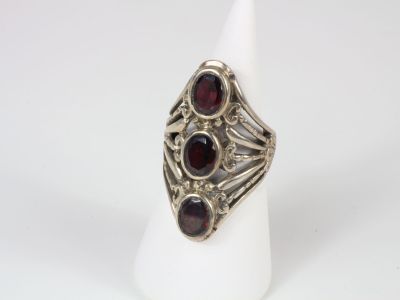 a close up of a silver ring with garnets on it