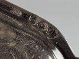 an antique silver plate with writing on the side of it
