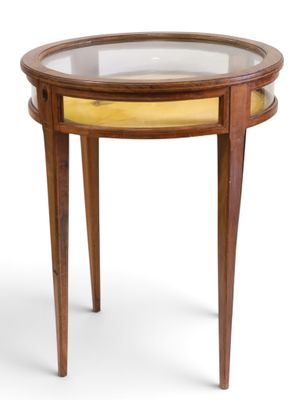 une image représentant une petite table avec un plateau en verre et des pieds en bois