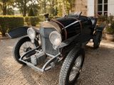 une voiture de collection garée devant une maison