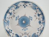 a blue and white plate with a flower design on it