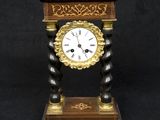 a clock that is sitting on a stand on a black background