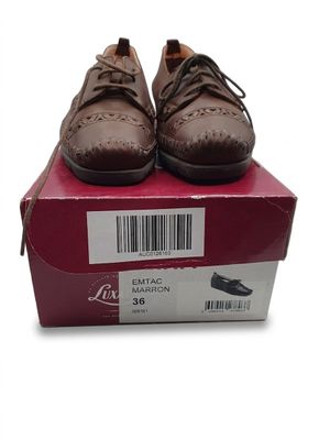 une paire de chaussures pour homme dans une boîte, sur fond blanc