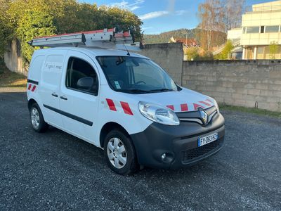 La camionnette blanche est garée sur le parking près d'un immeuble.