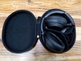 un casque audio dans son étui, posé sur une table en bois
