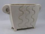 a white planter with a wavy design on it