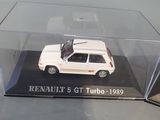 a small white car in a clear box on a table