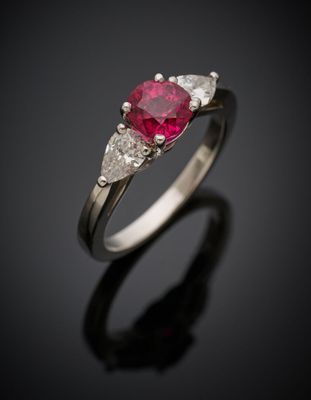 Gros plan sur une bague sertie d'un rubis et de diamants, posée sur une surface noire