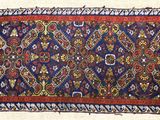 un vieux tapis avec une bordure rouge et un motif bleu et rouge