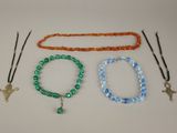 trois bracelets et un collier sont posés sur une table