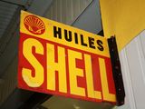 a shell sign hanging from the side of a building