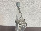 a glass bottle with a wire wrapped around it on a table