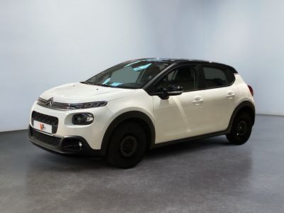 Une Citroën blanche est garée dans une pièce blanche