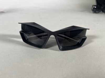 black sunglasses on a table with a camera and a pair of sunglasses