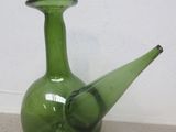 un vase en verre vert posé par terre