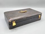 a black suitcase with a gold handle on a white surface