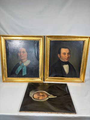 deux portraits encadrés représentant un homme et une femme, posés sur une table