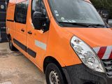 an orange van parked in a parking lot next to a dumpster