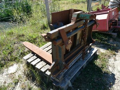 une machine qui se trouve dans l'herbe, près d'une clôture