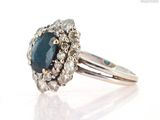 a close up of a ring with a blue diamond