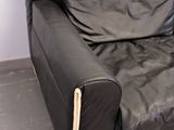 a black leather couch sitting in the corner of a room